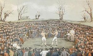 A typical 19th-century boxing match, often held in warehouses, courtyards of inns, or in open fields away from the eyes of local authorities. This painting was by Byrne's friend Jem Ward. | Wikipedia